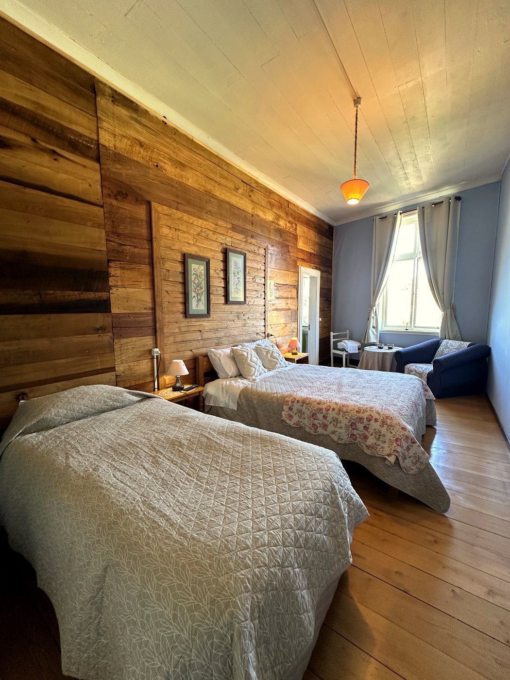 Habitación 4: cama matrimonial y cama adicional, con rincón de estar junto a la ventana